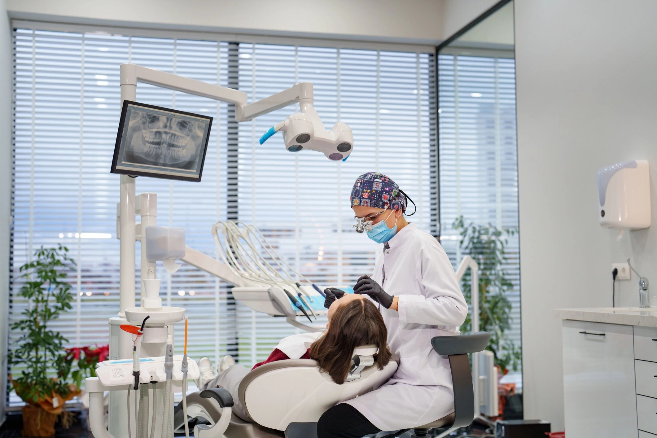 Dental professional examining a patient in a clinic room